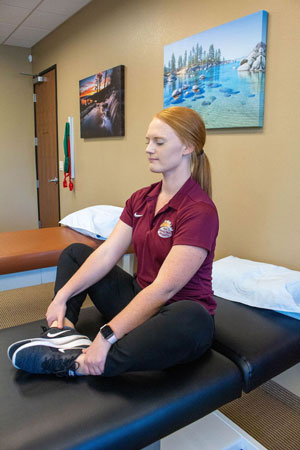 Therapist demonstrating the seated butterfly stretch